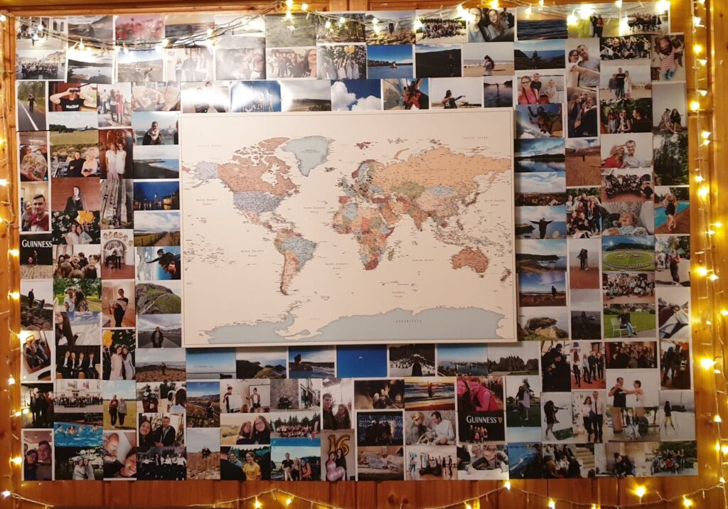 Reisekarte an einer mit Fotos bedeckten Wand